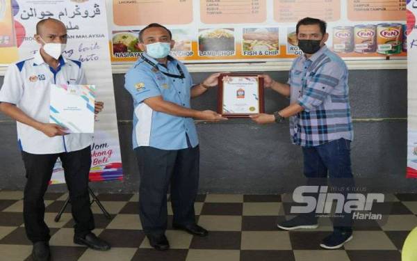 Adnan (tengah) menyampaikan sijil kepada peniaga yang memenangi AKHP 2021 di Kota Bharu pada Selasa.