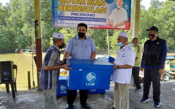 Syed Abu Hussin (dua dari kanan) menyampaikan kotak ikan berinsulasi di Jeti Kampung Menteri, Kuala Sepetang di sini pada Rabu.