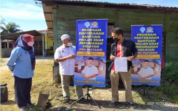 Syed Abu Hussin menyerahkan Surat Tawaran Program Khas Perumahan Nelayan Persatuan Nelayan Kawasan kepada penerima di Kampung Menteri, Kuala Sepetang, pada Rabu.