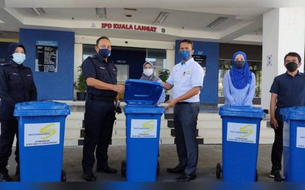 Mohd Idris (tiga dari kanan) menyerahkan tong sampah kepada Abdul Raheem (dua dari kiri) di IPD Kuala Langat pada Rabu.