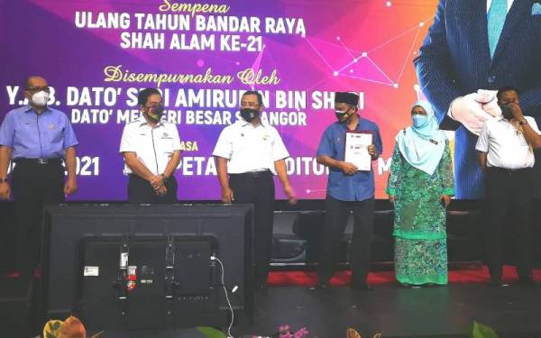 Amirudin (tiga dari kiri) merakamkam gambar bersama penerima lesen sementara pada Program Pembangunan Usahawan @ Shah Alam yang berlangsung di Auditorium Wisma MBSA pada Khamis.