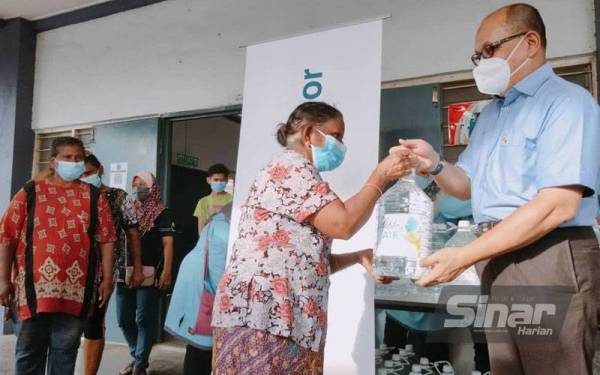 Penghun turut menerima 1,000 botol air minuman lima liter sumbangan Air Selangor disampaikan oleh Izham (kanan).