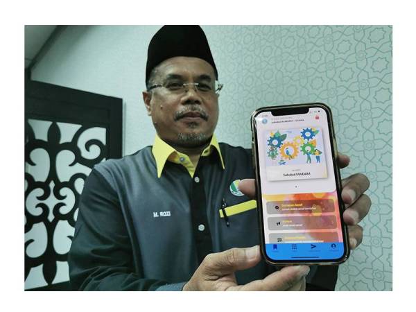 M. Rozi menunjukkan aplikasi Sahabat Maidam yang boleh dimuat turun pada telefon pintar bagi menyalurkan maklumat berkaitan asnaf kepada pihak Maidam.