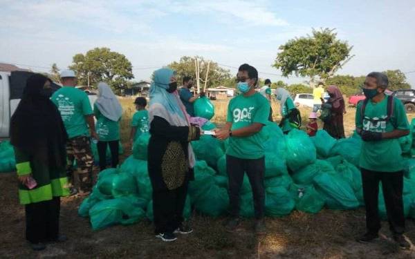 Dr Mohamed Ariff Hafizi (dua dari kanan) bersama Zuraida (tiga dari kanan) yang turut hadir ke program gotong royong membersihkan Pantai Pandak.