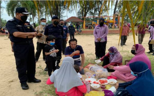 Shafien (kiri) bertanya khabar orang ramai yang beriadah di kawasan Pantai Geting, Tumpat pada Jumaat.