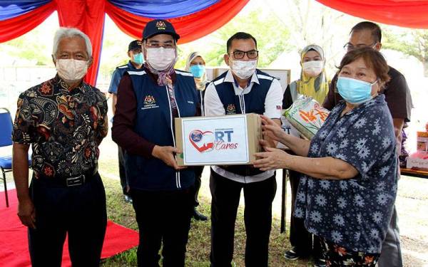 Halimah Mohamed Sadique (dua, kiri) menyampaikan kotak makanan pada program Perpaduan Komuniti Rukun Tetangga (KRT) RT Cares dan Kebun Komuniti di KRT Kampung Tersusun Kelebang Selatan hari ini. -Foto Bernama