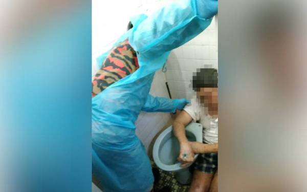 Pasukan Bomba dan Penyelamat memecahkan mangkuk tandas bagi mengeluarkan mangsa tersepit di celah mangkuk tandas di rumahnya di Wisma Sentosa, di Kuala Pilah, malam Sabtu. - Foto ihsan bomba