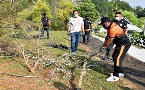 Kamel (kanan) mencantas dahan pokok sebagai simbolik Op Gerak Gempur Pembersihan Bersama Majlis Perbandaran Hang Tuah Jaya (MPHTJ) di Ayer Keroh, pada Ahad. Turut hadir, Shadan (dua, kiri). -Foto Bernama