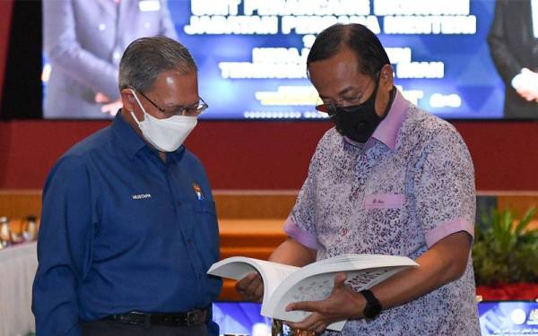 Mustapa (kiri) menerangkan mengenai buku RMK-12 kepada Ahmad Samsuri selepas sesi libat urus pasca RMK-12 bersama kerajaan negeri Terengganu di Wisma Darul Iman hari ini. -Foto Bernama