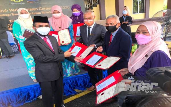 Dr Nik Muhammad Zawawi Salleh (dua dari kiri) beramah mesra dengan sebahagian penerima Anugerah Perkhidmatan Cemerlang Lembaga Kemajuan Pertanian Kemubu (KADA) tahun 2020 pada Isnin.