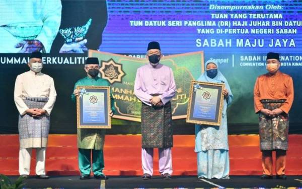 Tun Juhar (tengah) dan Hajiji (kanan) bersama dua penerima Anugerah Tokoh sempena sambutan Maulidur Rasul Peringkat Negeri Sabah di SICC, Kota Kinabalu pada Selasa.