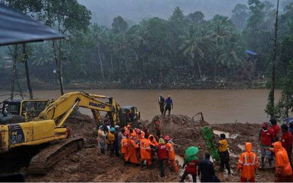 Petugas penyelamat membawa keluar mayat mangsa yang tertimbus akibat kejadian tanah runtuh yang berpunca daripada hujan lebat di kampung Kokkayar di daerah Idukki di selatan negeri Kerala, India. - Foto Reuters