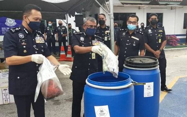 Ramli dan Mohd Yusri memasukkan dadah yang akan dilupuskan ke dalam tong yang disediakan untuk dihantar ke pusat pelupusan oleh kontraktor dilantik.