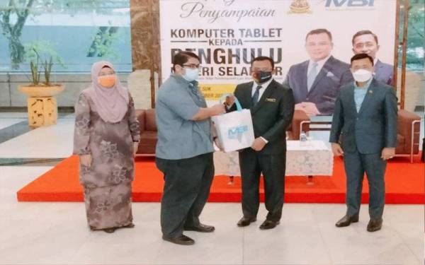 Borhan (kanan) mengiringi Amirudin menyampaikan tablet kepada penerima.