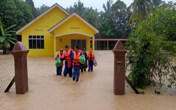 Anggota APM membantu memindahkan mangsa banjir ke PPS negeri ini.