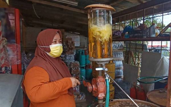 Norhayati menunjukkan isian minyak petrol secara tradisional dengan mengepam bahan api itu menggunakan tangan mencetuskan fenomena baharu dalam kalangan masyarakat khususnya dari luar Dabong.