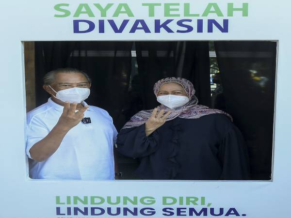 Pengerusi Majlis Pemulihan Negara (MPN) Tan Sri Muhyiddin Yassin (kiri) dan isteri Puan Sri Norainee Abdul Rahman bergambar selepas menerima dos ketiga atau dos penggalak vaksin Covid-19 di Pusat Pemberian Vaksin (PPV) Axiata Arena Bukit Jalil pada Sabtu. - Foto Bernama