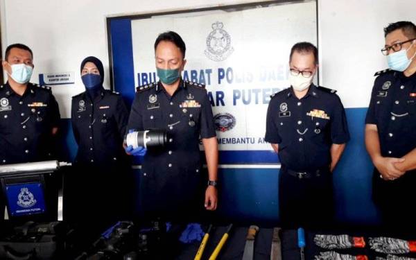 Dzulkhairi (tengah) menunjukkan tiga unit kamera dan lensa yang dirampas dalam serbuan di dua buah rumah di Skudai pada sidang akhbar di IPD Iskandar Puteri, Iskandar Puteri pada Sabtu.