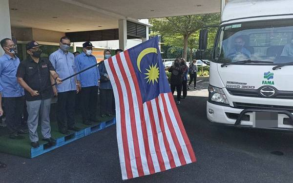 Ronald (kiri) menyempurnakan pelepasan sumbangan MAFI Prihatin kepada rakyat Malaysia yang terkandas di Singapura.