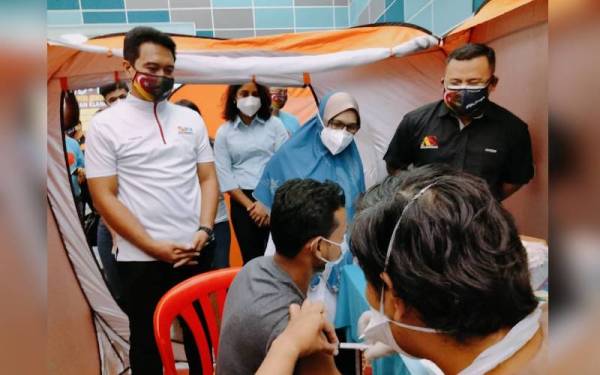 Amirudin (kanan) melawat pusat pemberian vaksin untuk golongan remaja yang diadakan di Dewan Serbaguna MPK Pandamaran Jaya.