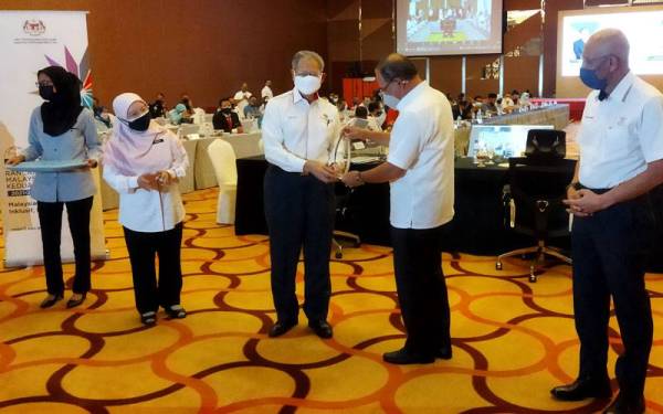 Wan Rosdy menyampaikan cenderamata kepada Mustapa selepas sesi Roadshow Pasca RMK12 oleh Unit Perancangan Ekonomi, Jabatan Perdana Menteri bersama kerajaan negeri Pahang di sebuah hotel di sini pada Ahad.