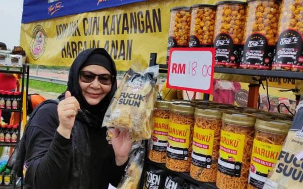 Erma bergambar bersama produk IKS tempatan yang dijual di tapak niaga GeniaSelangor MakCun@FAMA di pasar tani FAMA, Stadium Shah Alam, pada pagi Ahad.