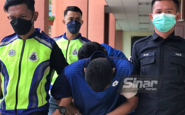 Muhammad Ahmad (depan) dan Mohd Hafidz dibawa keluar dari Mahkamah Majistret Taiping pada Rabu.