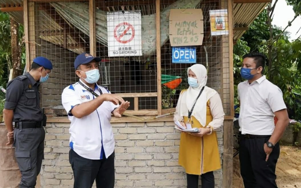 Adnan (dua dari kiri) semasa turun padang melakukan pemeriksaan berkala di pos menjual minyak petrol sekitar Dabong bagi memastikan pelanggaran undang-undang tidak berlaku di kawasan tersebut.