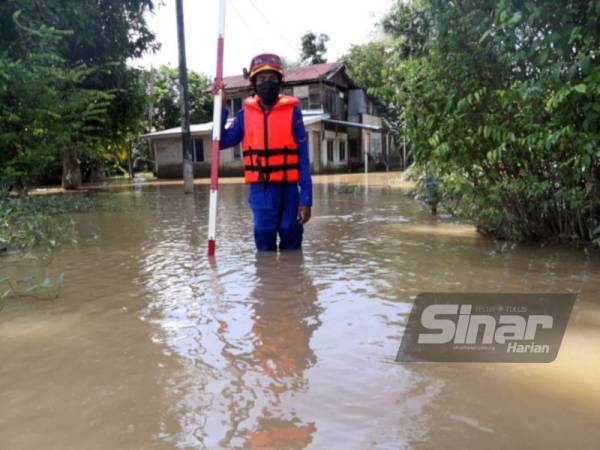 Anggota Angkatan Pertahanan Awam Malaysia (APM) Pendang melakukan pemantauan paras air di kawasan yang terjejas di Pendang pada Khamis.