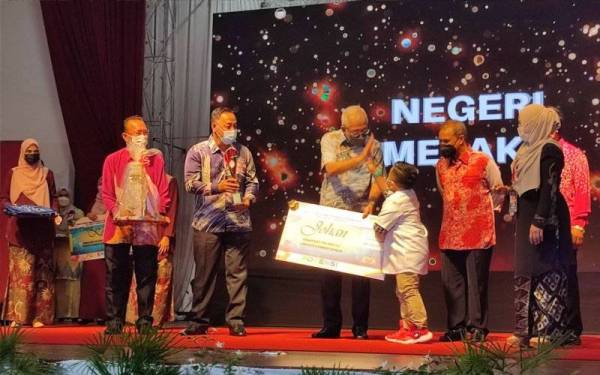 Mahdzir (tengah) menyerahkan hadiah kepada Johan Kemas Kid Top Host,Rizq Al Fateh Sarizal dari Melaka pada Majlis Penutupan dan Penyampaian Hadiah Hari Potensi Kemas Peringkat Kebangsaan Tahun 2021 Kali Ke-16 di Hotel Raia, di sini, pada Sabtu.