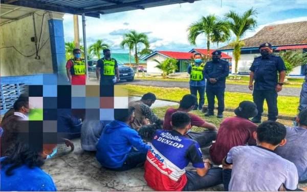 Ramli (empat dari kiri) memeriksa individu yang ditahan dalam Ops Sarang Khas di Lipis pada Ahad. - Foto PDRM