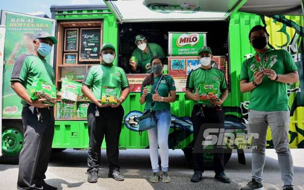 Fadhly (kanan) bersama kru perkhidmatan van Milo di pekarangan Kompleks Karangkraf pada Isnin.