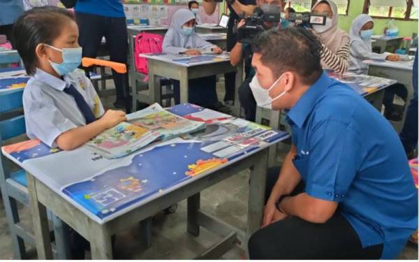 Radzi (kanan) bertemu dengan murid tahun satu di SK Ayer Molek, di sini, pada Isnin.