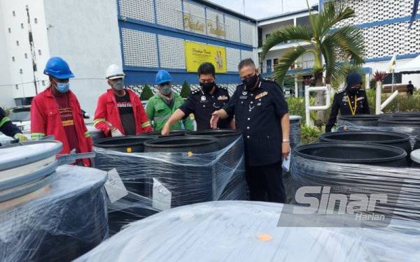 Mazlan (kanan) bersama Ketua JSJN Perak, Asisten Komisioner Lee King Chuan menunjukkan eksibit kes dadah yang akan dilupuskan di Ibu Pejabat Polis Kontinjen (IPK) Perak, Ipoh pada Selasa.