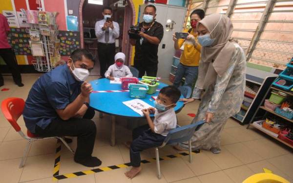 Menteri Kanan Pendidikan Datuk Dr Mohd Radzi Md Jidin (kiri) bersama murid Pra Sekolah Mohd Daniel Izhar (kiri) semasa mengadakan lawatan di Sekolah Kebangsaan Semaseh, Panchor hari ini. Foto Bernama