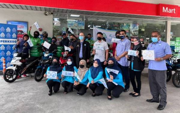 Saiful (berdiri tengah,baju putih) bergambar bersama sukarelawan dan pemandu p-hailing yang didaftarkan di bawah skim SPS di Larkin, Johor Bahru pada Isnin