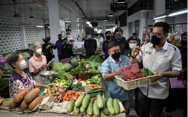 Mohd Ridzuan Ab Ghapar (kanan) melakukan pemeriksaan ketika tinjauan operasi Skim Harga Maksimum Musim Perayaan (SHMMP) Deepavali di Pasar Awam Chowrasta pada Selasa.