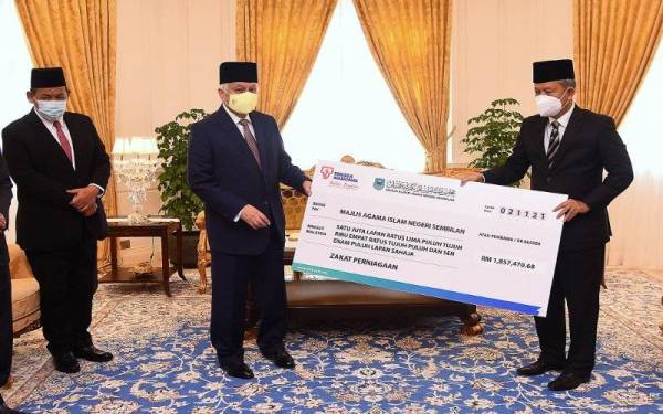 Tuanku Muhriz (tengah) berkenan menerima pembayaran zakat perniagaan daripada TNB yang disampaikan oleh Hasan (kanan) berjumlah RM1.86 juta di Istana Hinggap hari ini. Foto Bernama