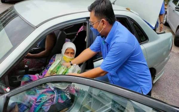 Saiful mengagihkan sayuran dan pisang kepada ibu tunggal pada program MAFI Prihatin Pekan di Kolej Komuniti Pekan pada Rabu.