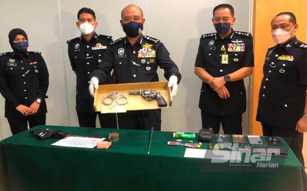 Ketua Polis Kelantan, Datuk Shafien Mamat (tengah) menunjukkan pistol jenis revolver.38 berwarna perak bertulis Smith dan Wesson yang dirampas. - FOTO SINAR HARIAN