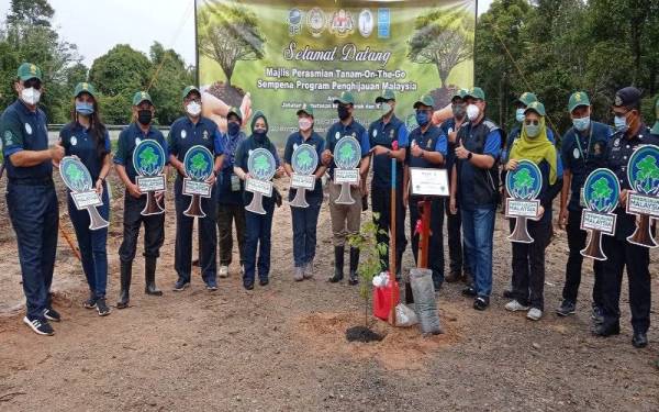 Mohd Ridza Awang bersama pegawainya selepas menanam pokok Merawan Siput Jantan Sempena Program Penghijauan Perak di R&R Puncak Titiwangsa Jalan Timur Barat pada Rabu. Foto Bernama