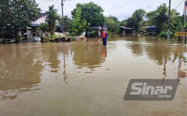 Anggota APM memantau paras banjir di Taman Tanjung Bendahara yang dinaiki air sedalam kira-kira 0.3 meter pada Khamis.