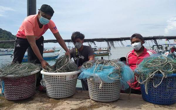 Nelayan dilihat memunggah peralatan menangkap ikan di Jeti Pulau Sayak, Kota Kuala Muda, Kedah.