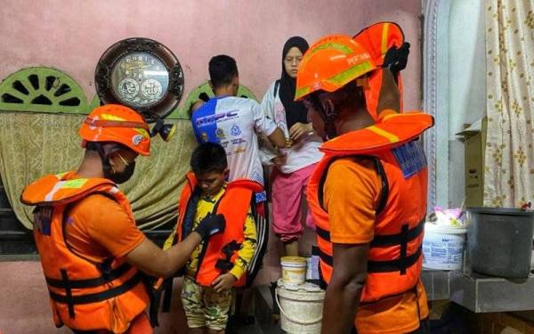 Skuad APM Sik menjalankan kerja-kerja menyelamat keluarga yang terperangkap dalam banjir di Kampung Jerai pada Sabtu.