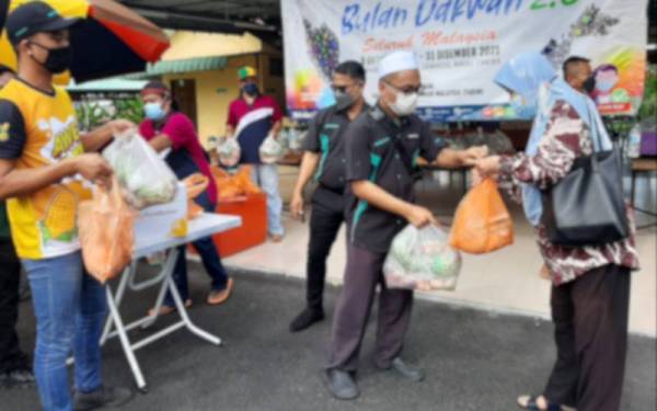 Hassanal (tengah) menyampaikan sumbangan kepada keluarga asnad di Taman Ampangan pada Sabtu.