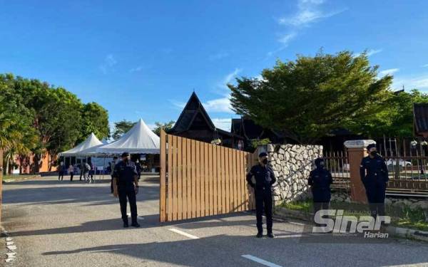 Anggota polis turut mengawal di bahagian pintu masuk ke Dewan Tun Ali, Bukit Katil bagi proses penamaan calon bagi Dewan Undangan Negeri (DUN) Bukit Katil yang bermula jam 9 pagi tadi.