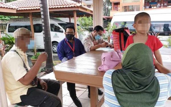 Nizam (kiri) bersama isteri dan anaknya disantuni pegawai Baitulmal MAIWP bagi membantu keluarga berkenaan.