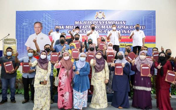 Hasni (tengah, belakang) bersama penerima geran hak milik generasi kedua Felda Inas di sini pada Khamis.