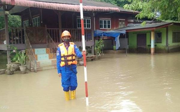 Anggota Angkatan Pertahanan Awam (APM) Pendang memantau paras air Sungai Pendang di Kampung Seberang Pendang pada Sabtu.