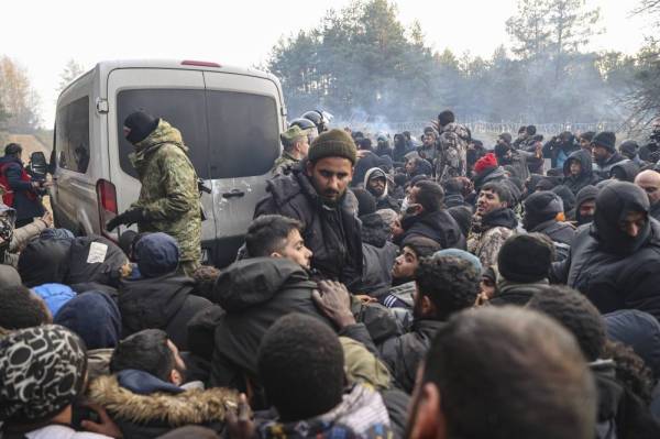 Asylum-seekers, refugees and migrants, gather to receive humanitarian aid distributed by Belarusian military at a camp at the Belarus-Polish border in the Grodno region, not far from the checkpoint Bruzgi, Belarus, Nov 12, 2021. Group of approximately 2,000 asylum-seekers, refugees and migrants who want to obtain asylum in the European Union have been trapped at low temperatures for four days at the border. (Photo by EPA)